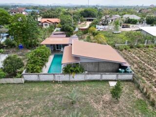 Aerial view of a suburban house with a swimming pool and garden