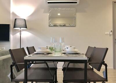 Modern dining area with set table, sleek chairs, and ambient lighting