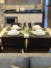 Modern dining area with set table and kitchenette