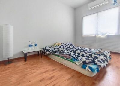 Cozy bedroom with large window and hardwood flooring