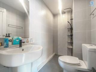 Modern bathroom with white fixtures including sink, toilet, and shower