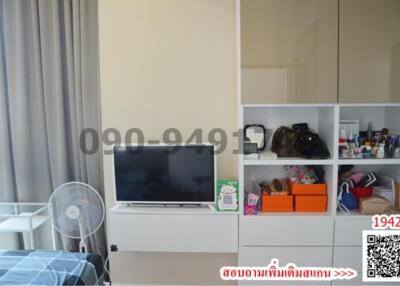 Modern bedroom interior with organized shelving unit and television