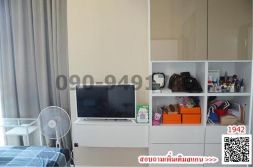 Modern bedroom interior with organized shelving unit and television