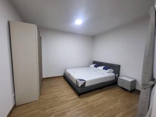 Spacious bedroom with hardwood floors and minimalistic decor