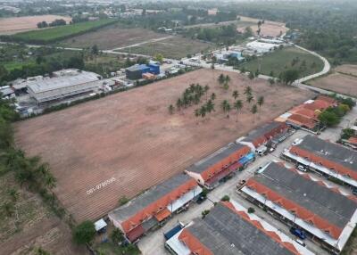 Aerial view of a large open land plot near residential area