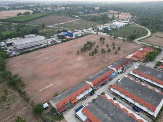 Aerial view of a large open land plot near residential area