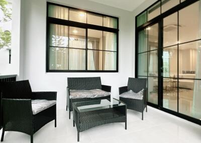 Modern patio area with stylish outdoor furniture and large windows