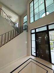 Modern foyer with high ceiling and elegant staircase