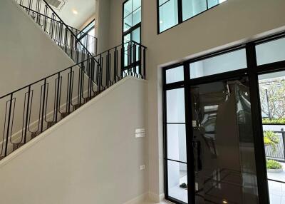 Modern foyer with high ceiling and elegant staircase