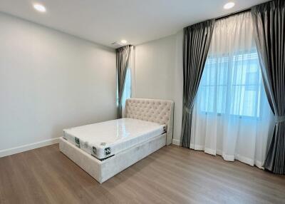 Spacious bedroom with large bed and hardwood floors