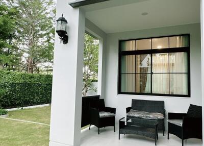 White modern house exterior with outdoor seating and garden