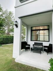 White modern house exterior with outdoor seating and garden
