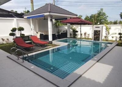 Private swimming pool with sun loungers and patio area in a residential property