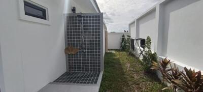 Modern outdoor shower area with tiled wall and flooring