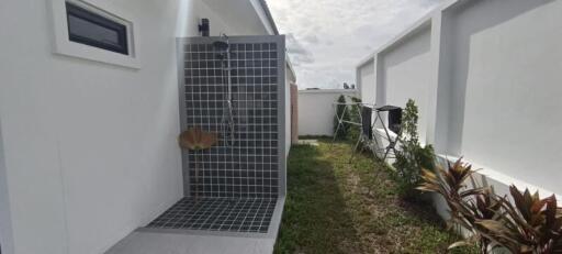 Modern outdoor shower area with tiled wall and flooring