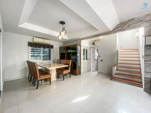 Spacious dining area with staircase and modern lighting