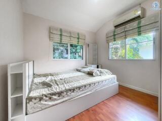 Cozy bedroom with natural light and wooden flooring