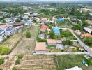 Aerial view of a residential area showing an array of buildings with various roof colors and surrounding greenery