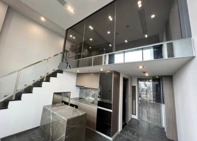 Modern interior of a multi-level home with glass railings and sleek kitchen design