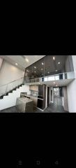 Modern interior of a multi-level home with glass railings and sleek kitchen design