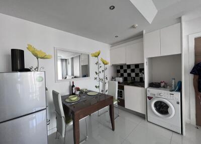 Modern kitchen with dining area, equipped with appliances and decorated with floral decals