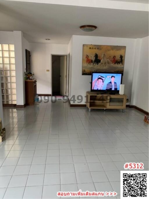 Spacious living room with white tiled flooring and mounted television