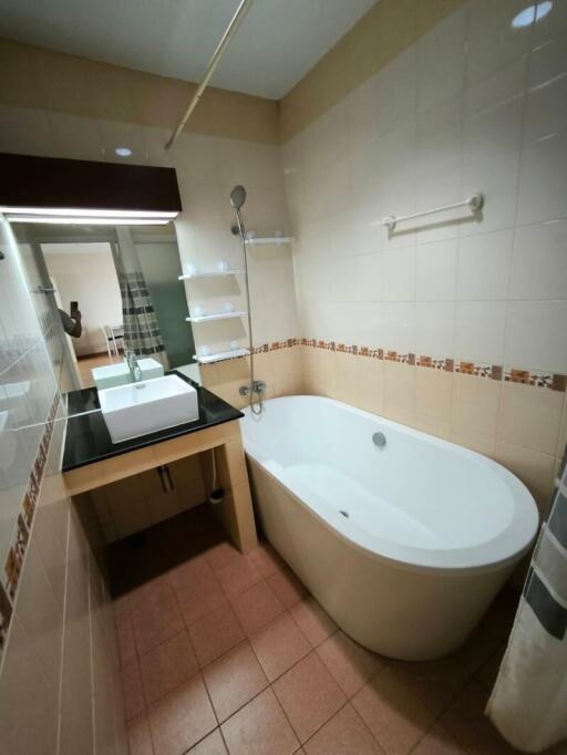 Modern bathroom with bathtub and mirrored vanity