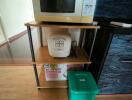 Compact kitchen corner with microwave, rice cooker, and trash bin