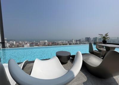 Luxurious rooftop infinity pool with a panoramic city view and modern lounge chairs