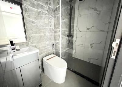 Modern bathroom with marble walls and glass shower