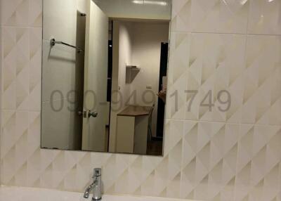 Modern bathroom with white ceramic sink and large mirror reflecting interior