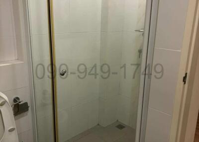 Compact bathroom with glass shower enclosure and toilet