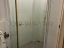 Compact bathroom with glass shower enclosure and toilet