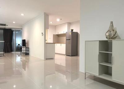 Modern open plan living room with kitchen and shiny tiled flooring