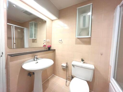 Spacious bathroom with tan tiles and modern fixtures