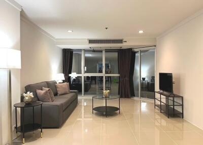 Modern living room interior with comfortable sofa and entertainment setup leading to a balcony