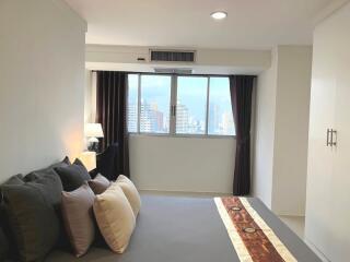 Modern bedroom with large windows and city view