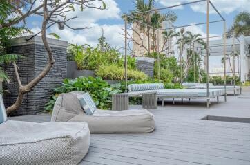 Modern outdoor lounge space with comfortable seating and lush greenery