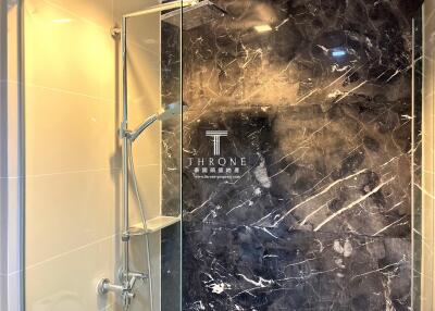 Luxurious bathroom with marble walls and glass shower enclosure