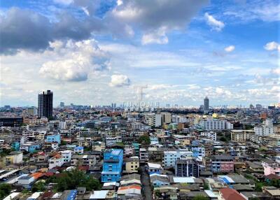 Expansive cityscape with various buildings under a cloudy sky