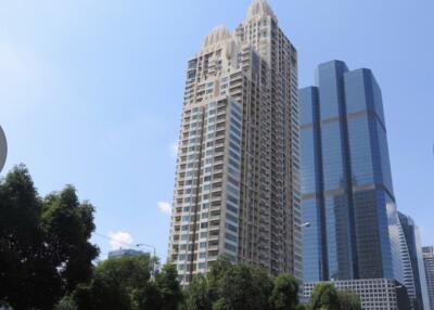 Exterior view of a modern high-rise residential building with blue sky in the background