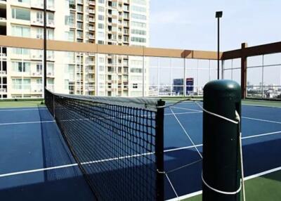 Residential building rooftop tennis court with cityscape