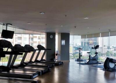 Modern gym facility in a residential building with treadmills overlooking the city