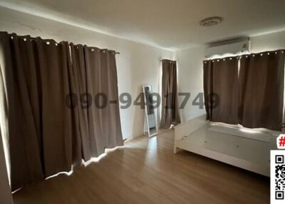 Spacious bedroom with natural lighting and hardwood floors