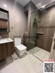 Modern bathroom with glass shower and wooden cabinet