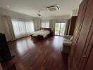 Spacious bedroom with hardwood floors and ample natural light