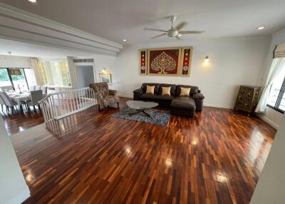 Spacious living room with polished hardwood floors and elegant decor