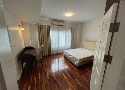 Spacious bedroom with ample natural light and hardwood flooring
