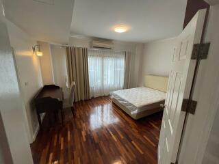 Spacious bedroom with ample natural light and hardwood flooring