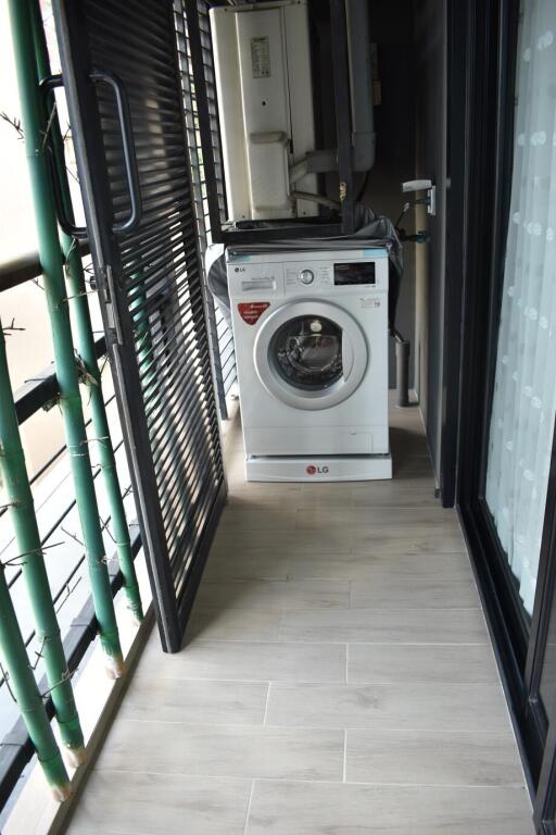 Compact balcony with a washing machine and bamboo plants